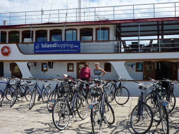 Along with a fellow-rider, Cheryl inspects the bicycles.